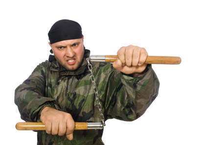 Young man in soldier uniform holding nunchaks isolated on whiteの写真素材