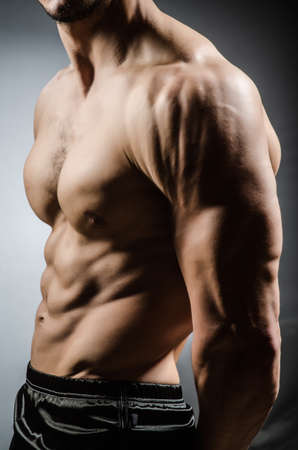 Muscular man posing in dark studioの写真素材