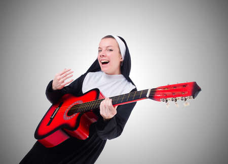 Nun playing guitar against the gradientの写真素材