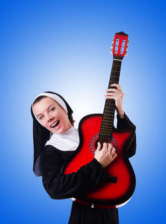 Nun playing guitar against the gradientの写真素材