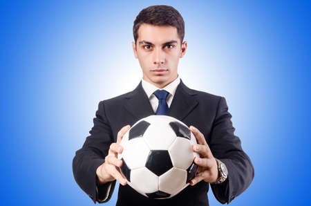 Young businessman with football against the gradientの写真素材