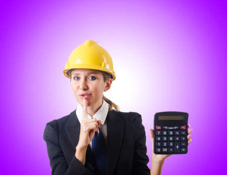Female construction worker with calculatorの写真素材