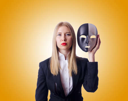 Woman with mask in hypocrisy conceptの写真素材