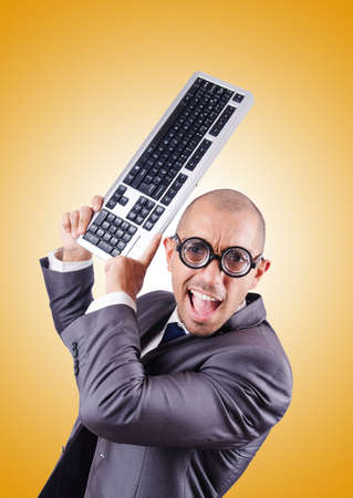 Nerd businessman with computer keyboard against gradientの写真素材