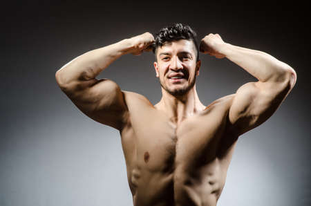 Muscular man posing in dark studioの写真素材