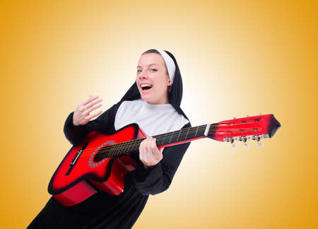 Nun playing guitar against the gradientの写真素材