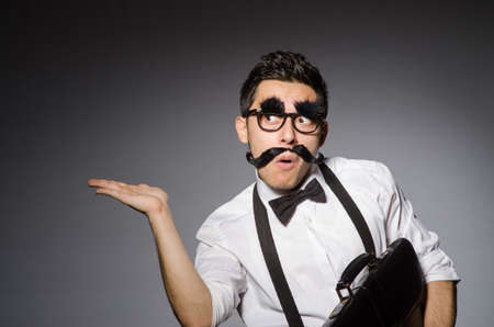 Young man with false moustache isolated on grayの写真素材