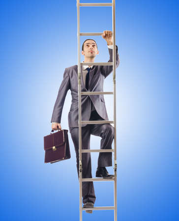Businessman climbing the ladder against the gradientの写真素材