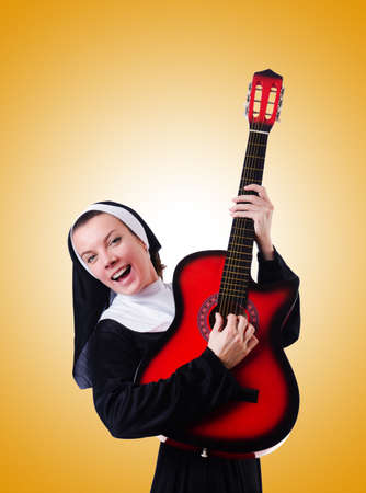 Nun playing guitar against the gradientの写真素材