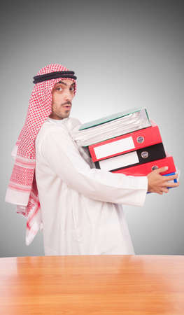 Arab businessman with many folders against gradientの写真素材