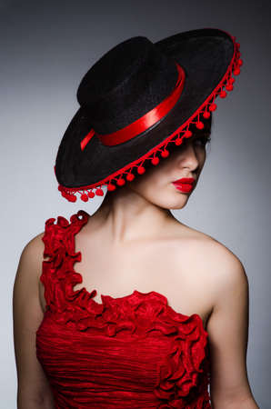 Woman wearing hat against dark backgroundの写真素材