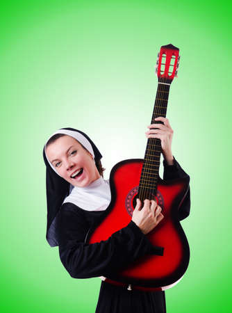 Nun playing guitar against the gradientの写真素材
