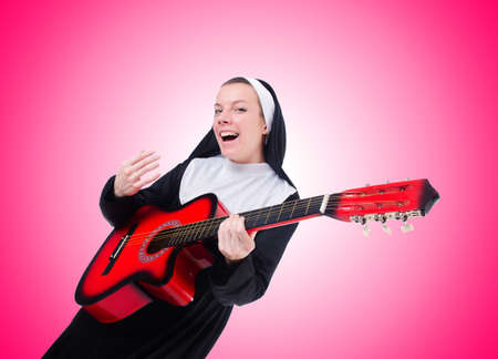 Nun playing guitar against the gradientの写真素材