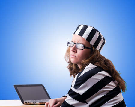 Criminal hacker with laptop against gradientの写真素材