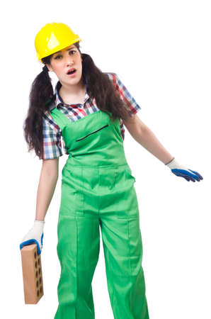 Female workman in green overalls holding brick isolated on whiteの写真素材