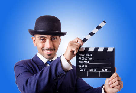 Man with movie clapper against the gradient