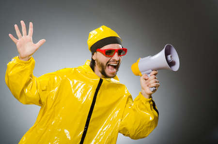 Man wearing yellow suit with loudspeakerの写真素材