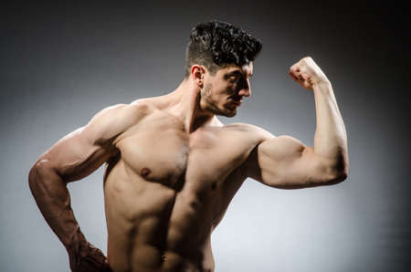 Muscular man posing in dark studioの写真素材