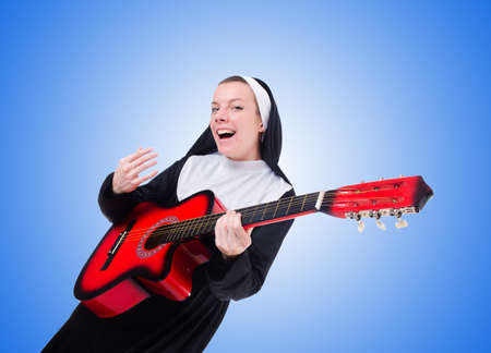 Nun playing guitar against the gradientの写真素材