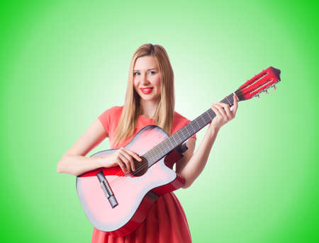 Woman playing guitar against the gradientの写真素材
