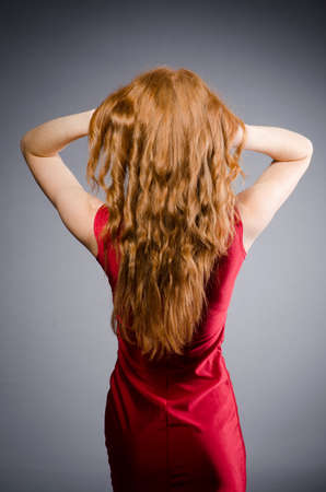 Pretty young girl in red dress isolated on whiteの写真素材