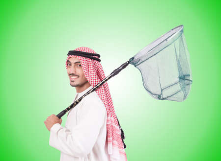 Arab businessman with catching net against gradientの写真素材