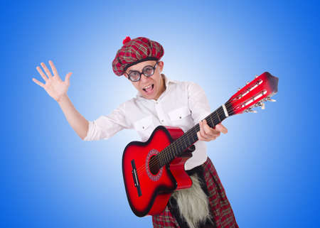 Funny scotsman with guitar on whiteの写真素材