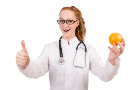 Pretty female doctor with stethoscope and orange isolated on whiteの写真素材