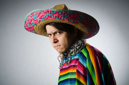 Man in vivid mexican poncho against grayの写真素材