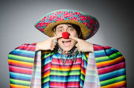 Man in vivid mexican poncho against gray