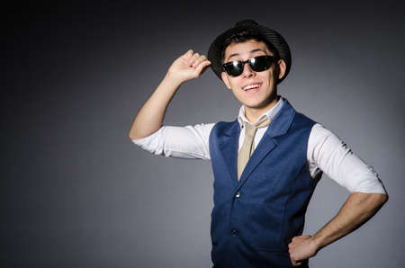 Young man in blue vest and hat against grayの写真素材