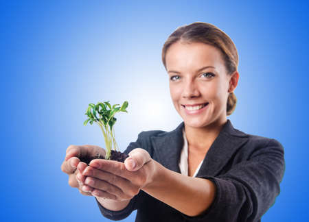 Businesswoman with seedling on whiteの写真素材