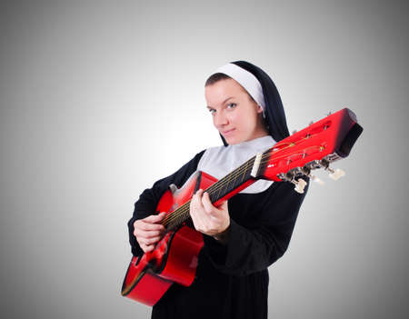 Nun playing guitar against the gradientの写真素材