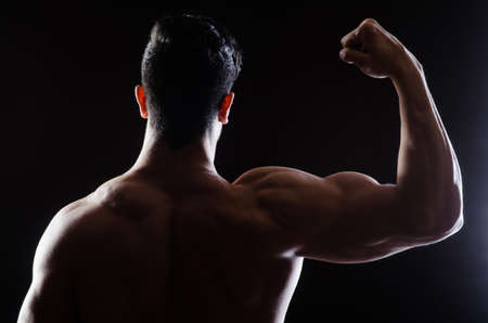 Muscular man posing in dark studioの写真素材