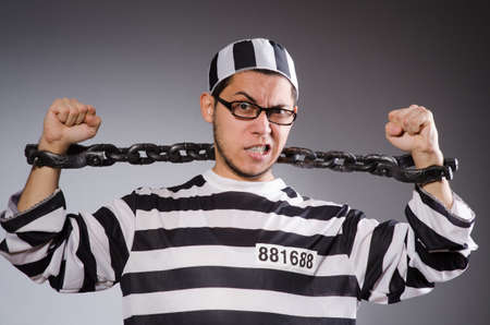 Young prisoner in chains against grayの写真素材