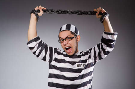 Young prisoner in chains against grayの写真素材