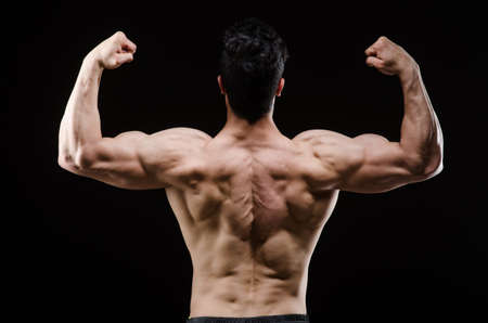 Muscular man posing in dark studioの写真素材