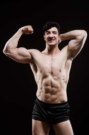 Muscular man posing in dark studioの写真素材