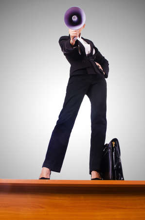 Businesswoman shouting through loudspeakerの写真素材