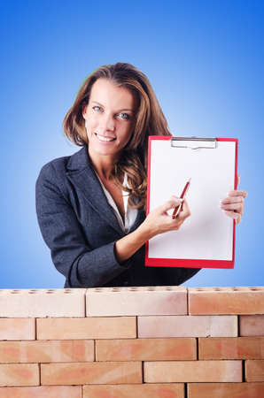 Woman builder and brick wallの写真素材