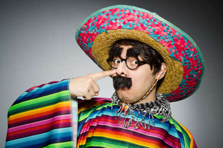 Man in vivid mexican poncho against grayの写真素材