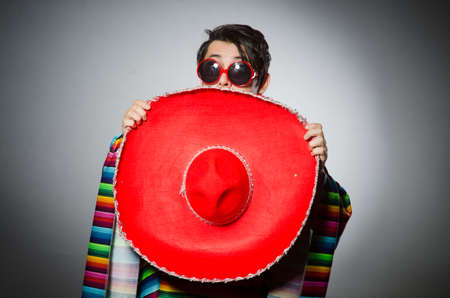 Man in vivid mexican poncho against grayの写真素材