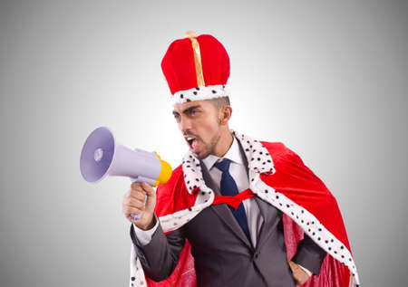 King businessman with loudspeaker isolated on whiteの写真素材