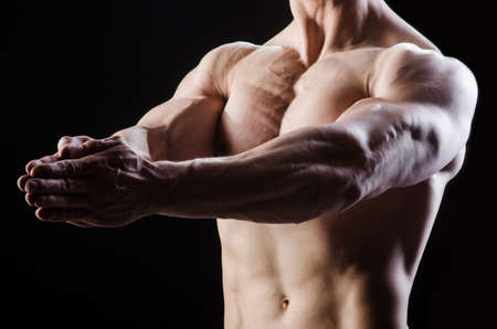 Muscular man posing in dark studioの写真素材