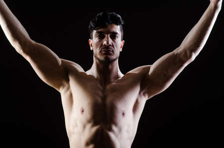 Muscular man posing in dark studioの写真素材
