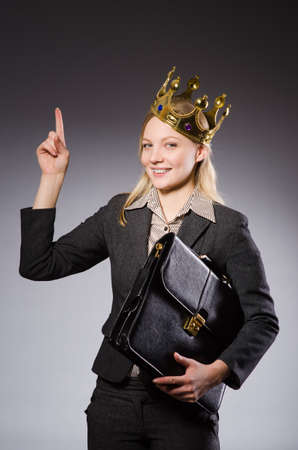 Businesslady wearing crown against grayの写真素材