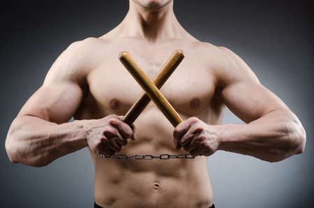 Muscular strong man with nunchucksの写真素材