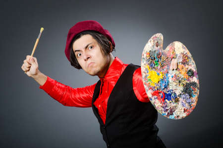 Funny artist in dark studioの写真素材