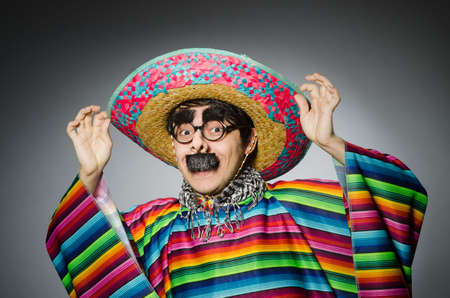 Man in vivid mexican poncho against grayの写真素材