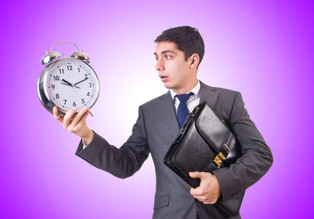 Businessman with clock isolated on whiteの写真素材